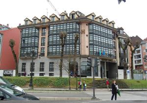 un grand bâtiment avec des personnes qui marchent devant lui dans l'établissement Astures, à Oviedo