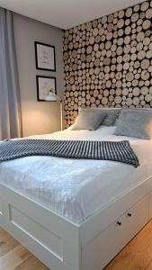 um quarto com uma cama branca e uma cabeceira em madeira em Apartamenty Granitica Zakopane em Zakopane