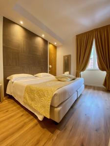 a bedroom with a large bed and a large window at Hotel Centrale in San Pellegrino Terme