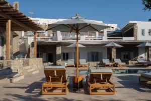 a patio area with chairs, tables and umbrellas at Argo Hotel in Platis Gialos