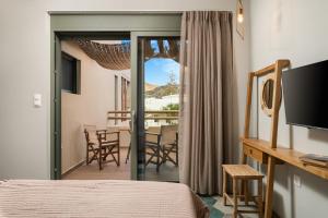 a hotel room with a bed and a balcony at Villas Plumeria in Palaiochora