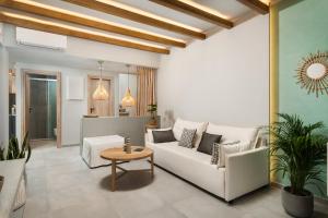 a living room with a white couch and a table at Villas Plumeria in Palaiochora