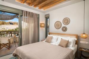 a bedroom with a bed and a balcony at Villas Plumeria in Palaiochora