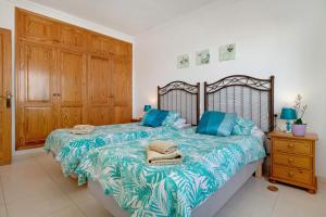 a bedroom with two beds with blue pillows on it at Villa Carolina in Tías +34 photos