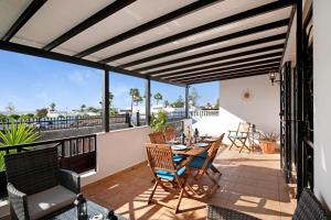 a patio with a table and chairs on a balcony at Villa Carolina in Tías