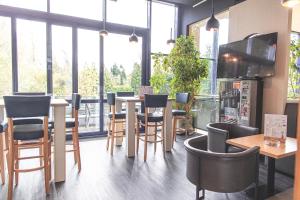 a restaurant with a table and chairs and windows at Best Western Plaza Hotel Zwickau in Zwickau