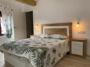 1 dormitorio con 1 cama con edredón verde y blanco en Alojamiento con amplio salón y chimenea., en Valverde