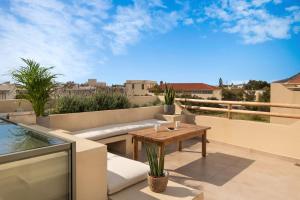 a patio with a wooden table on a balcony at Villas Plumeria in Palaiochora