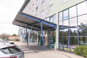 a glass building with a parking lot in front of it at Best Western Plaza Hotel Zwickau in Zwickau