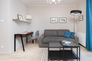 a living room with a couch and a table at Platinum Tartaczna Apartments by Renters in Gdańsk