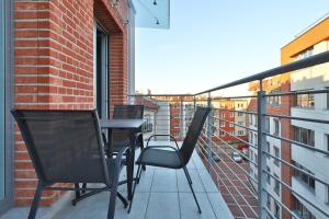 een balkon met 2 stoelen en een tafel op een gebouw bij Platinum Tartaczna Apartments by Renters in Gdańsk