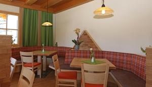a dining room with two tables and a couch at Alpenperle in Ramsau am Dachstein +12 photos