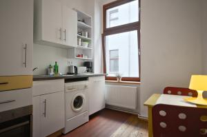 a kitchen with a washing machine and a window at Courtyard Apartment (REBELI) in Berlin