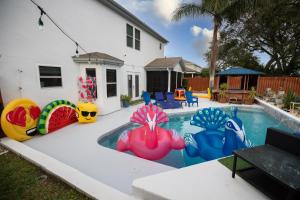 un patio trasero con una piscina con coloridos inflables en Gorgeous Urban Oasis withHot Tub, HEATED POOL and Private Movie Theater home, en Viera