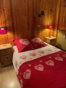 1 dormitorio con 1 cama con sábanas y almohadas rojas en Le Petit Chalet, en Auron
