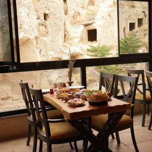 a wooden table with plates of food on it at Pome Granate Cave Hotel in Nevşehir