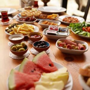 uma mesa de madeira com pratos de comida em Pome Granate Cave Hotel em Nevşehir