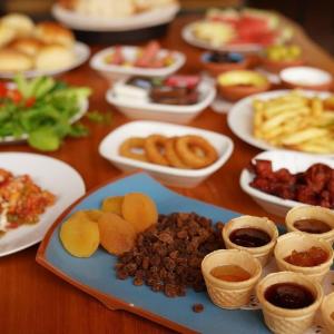 a wooden table with plates of food on it at Pome Granate Cave Hotel in Nevsehir