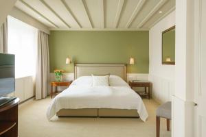 a bedroom with a white bed and a window at Suvretta House in St. Moritz