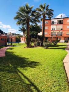 un parque con palmeras frente a un edificio en apartamento Torreblanca del sol Beach en Fuengirola