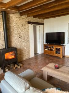 a living room with a fireplace and a television at Theuville maison les Bornes in Theuville