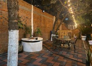 d'une terrasse avec une baignoire et une table avec des chaises. dans l'établissement Departamento Magnolia, 5 min AEROPUERTO, à Nextetelco