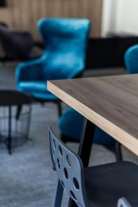 a wooden table and blue chairs in a room at Hôtel des Halles in Dijon +57 photos