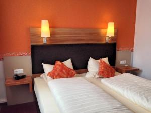 ein Schlafzimmer mit einem großen Bett mit orangefarbenen Wänden in der Unterkunft Hotel Café Konditorei Köppel in Bingen am Rhein