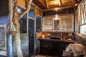 侯斯普瑞特hippomoon lodge game reserve的一间带水槽和树的浴室