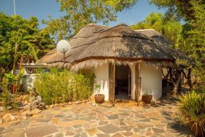 a house with a thatched roof and a patio at hippomoon lodge in Hoedspruit