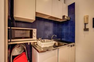 una pequeña cocina con fregadero y microondas en M&L Apartments - Ardesia Colosseo, en Roma