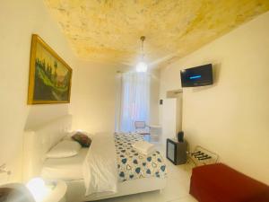 ローマにあるI ドルミエンティのベッドルーム(ベッド1台、ソファ、テレビ付)