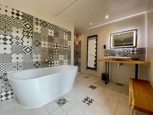 a large bathroom with a tub and a sink at Le Moulin Fouret in Saint-Aubin-le-Vertueux