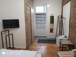 a living room with a tv and a brick wall at Gogol 14 Апартаменти в історичному центрі міста in Uzhhorod