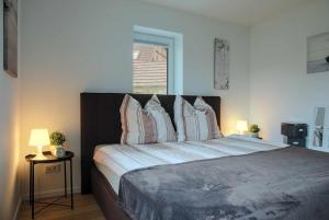 a bedroom with a large bed with pillows at Das Ferienhaus an der Weser in Bodenfelde