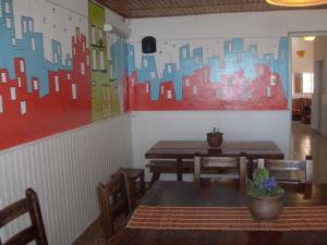 un restaurant avec des tables et des chaises et une peinture murale. dans l'établissement Shanti Hostel, à San Rafael