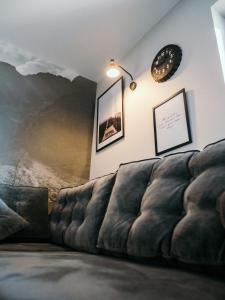kanapa w salonie z zegarem na ścianie w obiekcie Willa Pachówka w Bukowinie Tatrzańskiej