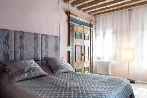 Un dormitorio con una cama con cabecero de madera. en Scala Mata, en Venecia