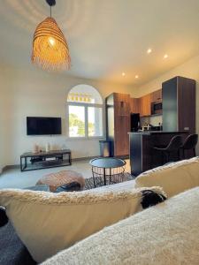ein Wohnzimmer mit einem Sofa und einem Tisch in der Unterkunft AU BORD DE L'EAU Studio climatisé avec Terrasse et vue mer à 40m de la plage in Cassis