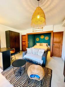 a bedroom with a bed and a chandelier at AU BORD DE L'EAU Studio climatisé avec Terrasse et vue mer à 40m de la plage in Cassis
