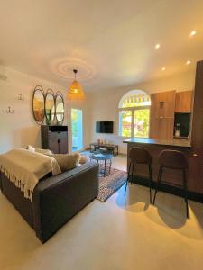 een grote woonkamer met een bank en een keuken bij AU BORD DE L'EAU Studio climatisé avec Terrasse et vue mer à 40m de la plage in Cassis