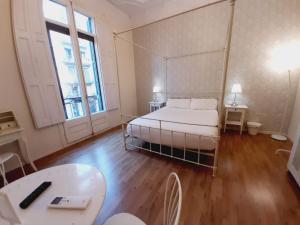Habitación grande con cama y mesa. en Lumine Luxury Suites by gaiarooms, en Barcelona