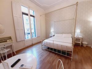 1 dormitorio con cama, escritorio y mesa en Lumine Luxury Suites by gaiarooms, en Barcelona