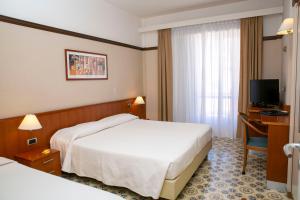 ein Hotelzimmer mit 2 Betten und einem TV in der Unterkunft Hotel Pietra di Luna in Maiori