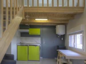 eine Küche mit grünen Schränken und einer Holztreppe in der Unterkunft Gîte La Chapelle-Basse-Mer, 3 pièces, 6 personnes - FR-1-306-814 in La Chapelle-Basse-Mer