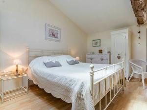 een slaapkamer met een groot wit bed en een stoel bij Gîte Monnières, 2 pièces, 2 personnes - FR-1-306-818 in Monnières