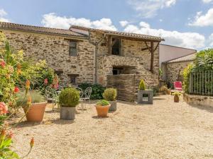 een stenen huis met potplanten in een tuin bij Gîte Monnières, 2 pièces, 2 personnes - FR-1-306-818 in Monnières