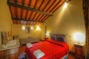 a bedroom with a red bed and a wooden ceiling at Holiday Home Il Moro Novo in Cortona