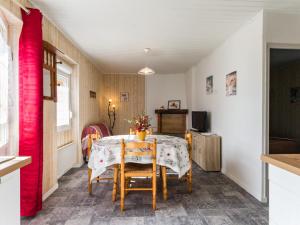 ein Esszimmer mit einem Tisch und einem roten Vorhang in der Unterkunft Gîte Frossay, 2 pièces, 2 personnes - FR-1-306-1027 in Frossay