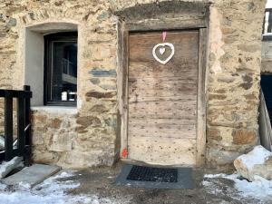 drewniane drzwi z znakiem serca w obiekcie Appartement Le Ponteil w mieście Les Deux Alpes